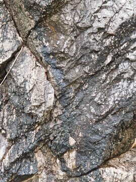 Natural raw rock texture and rough stone surface background with cracked geological details