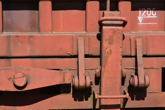 Industrial heavy duty locking mechanism and technical markings on a weathered rusty brown freight train car wall.