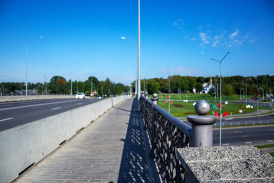 Paved pedestrian walkway on bridge with metal railings and blue sky with copy space outdoors for urban travel concepts