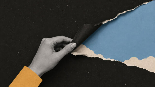 Hand peeling back a torn sheet of starry night paper to reveal open sky and clouds, paper collage. Change, optimism and new beginnings, copy space