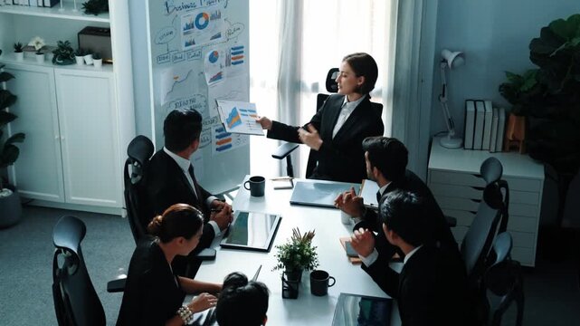 Top view of smart executive manager holding stock market investment chart while planning marketing strategy with diverse group. Smart business team brainstorming and working together. Directorate.