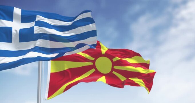 Flags of Greece and North Macedonia waving in the wind on a clear day