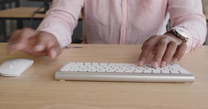 Man hands typing on keyboard at office desk, focusing on work
