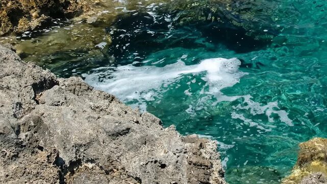 Video of coastal rocks and stones on the bottom with clear Mediterranean sea water. Crete, Greece