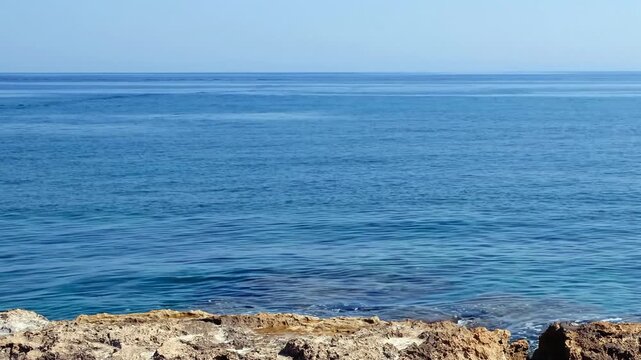 Video of the rocky shore of Crete Island with blue clear Mediterranean sea water. Greece