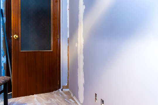 Home renovation work in progress, drywall being repaired and painted