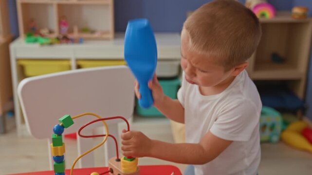 Brother and sister kneel and sort toys, reaching with hands into storage bins and handling a toy car, in a playroom building; playful cooperation.