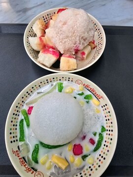 น้ำแข็งใส A refreshing Thai-style shaved ice topped with pandan lod chong,crispy  ruby water chestnuts,jackfruit, and sweet corn.
