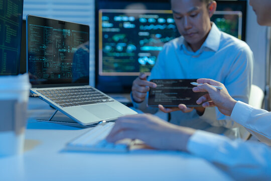 Male coder or developer working overtime using a computer display in problem solving at workplace.