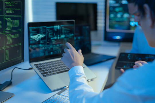 Male coder or developer working overtime using a computer display in problem solving at workplace.