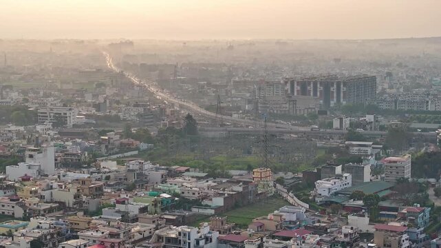 An aerial view of Dehradun, an Indian city during sunrise or sunset, with cloudy weather and rows of residential houses.