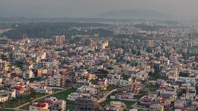 An aerial view of Dehradun, an Indian city during sunrise or sunset, with cloudy weather and rows of residential houses.
