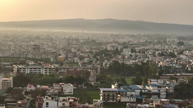 An aerial view of Dehradun, an Indian city during sunrise or sunset, with cloudy weather and rows of residential houses.