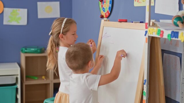 Girl restrains and pulls boy's arm away from marker at easel whiteboard in preschool classroom building; sibling tension frustration.