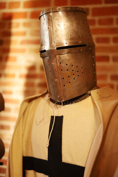 Medieval knight wears heavy, perforated helmet