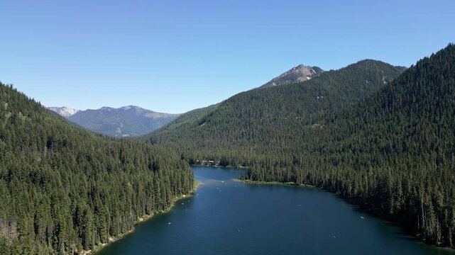 Lake with evergreen forest landscape. Landscape of mountain and forest lake. Nature landscape. Lake in scenic nature. Scenic forest nature at hiking lake. Mountain green forest