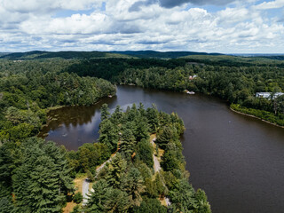 Fototapeta premium Aerial view of a scenic waterway with forested islands and lush green landscape in Rawdon, Quebec, Canada