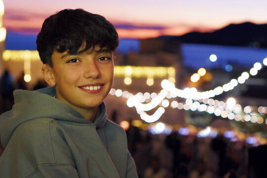 Portrait of a teenager enjoying a Christmas market with out-of-focus lights in the background