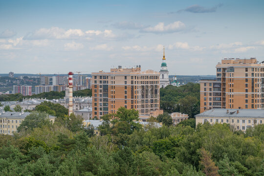 Urban landscape of Tula city showcasing modern buildings amidst lush greenery and historical architecture beneath a cloudy sky