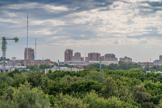Cityscape of Tula against a backdrop of lush greenery and dramatic clouds showcasing urban life and nature in harmony