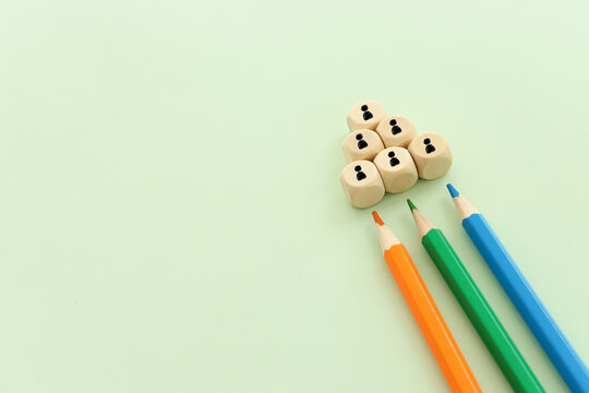 Top view image of pencils on green textured paper and wooden cubes