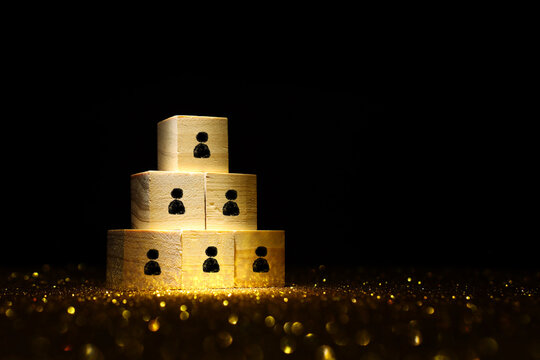 wooden cubes with people figures on dark background, human resources, leadership and management concept