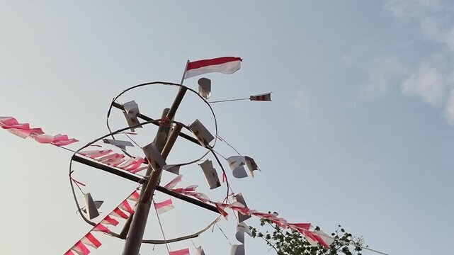 Close-up of a greased pole being prepared for Panjat Pinang, a traditional Indonesian game celebrating Independence Day and local cultural heritage.
