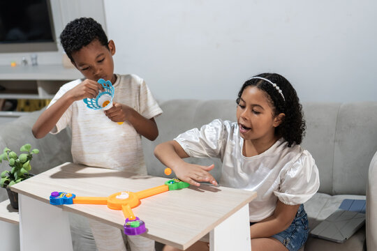 Young children playing interactive board game at home