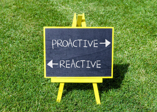 Proactive and reactive symbol. Concept word Proactive Reactive on beautiful yellow blackboard. Beautiful green grass background. Business proactive and reactive concept. Copy space.