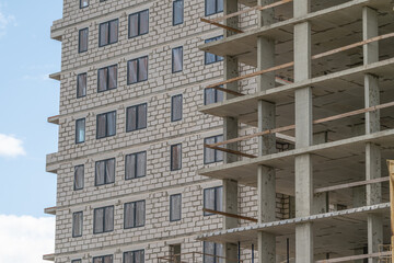 Construction of a modern apartment building showcasing ongoing work on multiple floors in a city setting © beholdereye