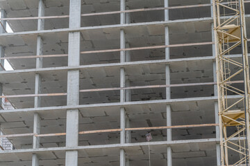 Construction in progress at a high-rise building showing concrete structure and scaffolding © beholdereye
