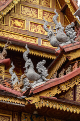 Fototapeta premium Dai temple roof with mythical bird sculptures in Jinghong, Xishuangbanna, Yunnan, China