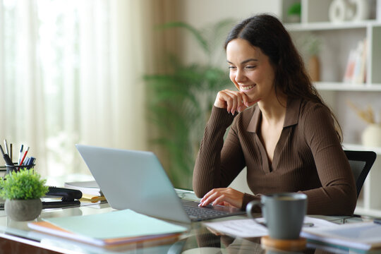 Pensive happy young telecommuter working at home