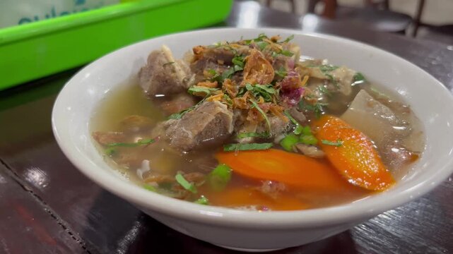 Traditional Indonesian beef soup served in a bowl with carrots and fried shallots