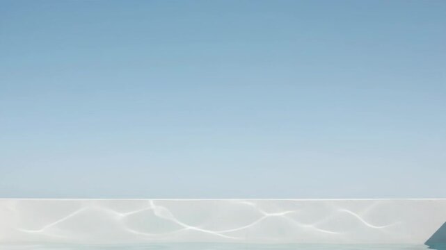 Light Caustics Ripple on White Poolside Wall Against Clear Blue Sky