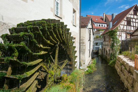 Historic water wheel beside a clear stream in Bad Urach