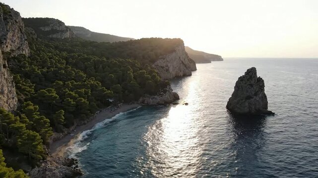 Aerial view of mediterranean coastal cliffs and sea stack at sunset, scenic ocean landscape with golden hour sunlight