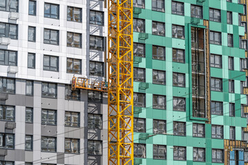 Workers skillfully complete exterior work on a modern high-rise building in a bustling urban center during a sunny day © beholdereye