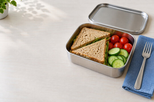 Packed sandwich lunch with vegetables in a reusable stainless steel lunchbox