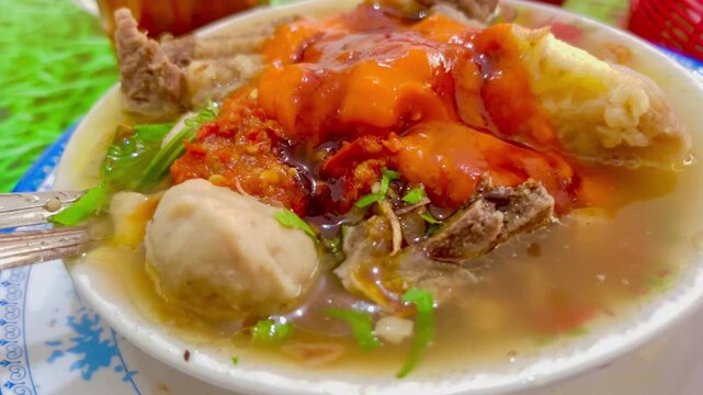 Indonesian meatball soup Bakso served in a bowl with chili sauce and broth