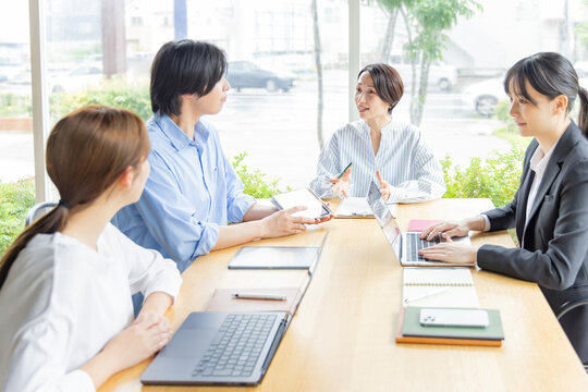明るい会議室で意見交換する日本人ビジネスチーム