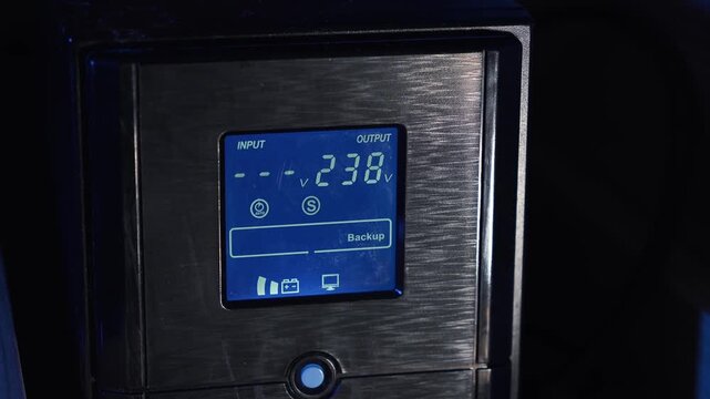 Computer UPS powered by a battery; backup power for equipment. Display showing battery charge percentage. Concept of backup power supply and energy independence. Electricity, storage, blackout
