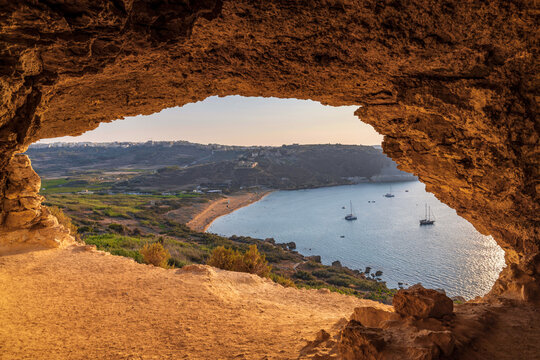 Scenic view of Ramla Bay beach through the opening of Mixta Cave in Gozo, Malta