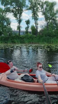 Middle-aged couple paddling orange tandem kayak on river promoting teamwork and active lifestyle