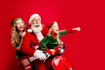 Naklejka premium Santa with two cheerful helpers riding a red scooter celebrating Christmas joy and family fun with elves and holiday excitement