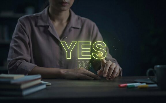 Woman sitting at wooden desk pointing at glowing holographic yes and no decision options text