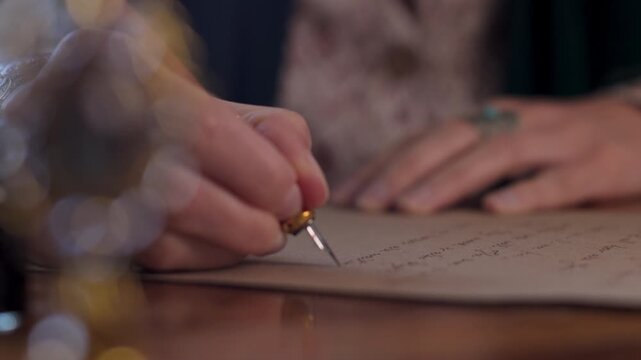 The girl is holding a pen with ink and writing a letter. The girl writes the letter in handwritten font. signing the document. 
