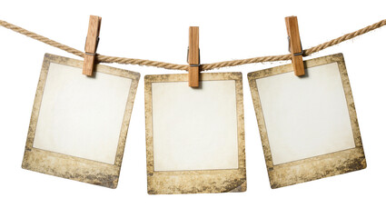 Three vintage instant photo frames hanging on a rope with wooden clothespins, isolated on transparent background © Aliona