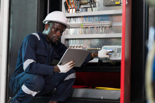 Electrician inspecting electrical panel. Electrician installing circuit breaker in electrical panel. Male electrician checking electrical control system