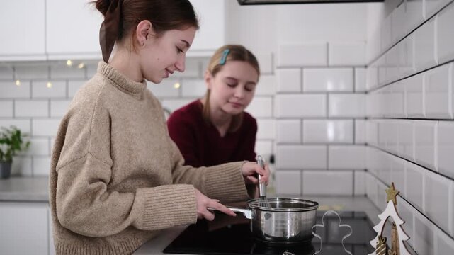 Sisters Melt Ingredients On The Stove, Preparing Gingerbread Cookies For A Christmas Celebration